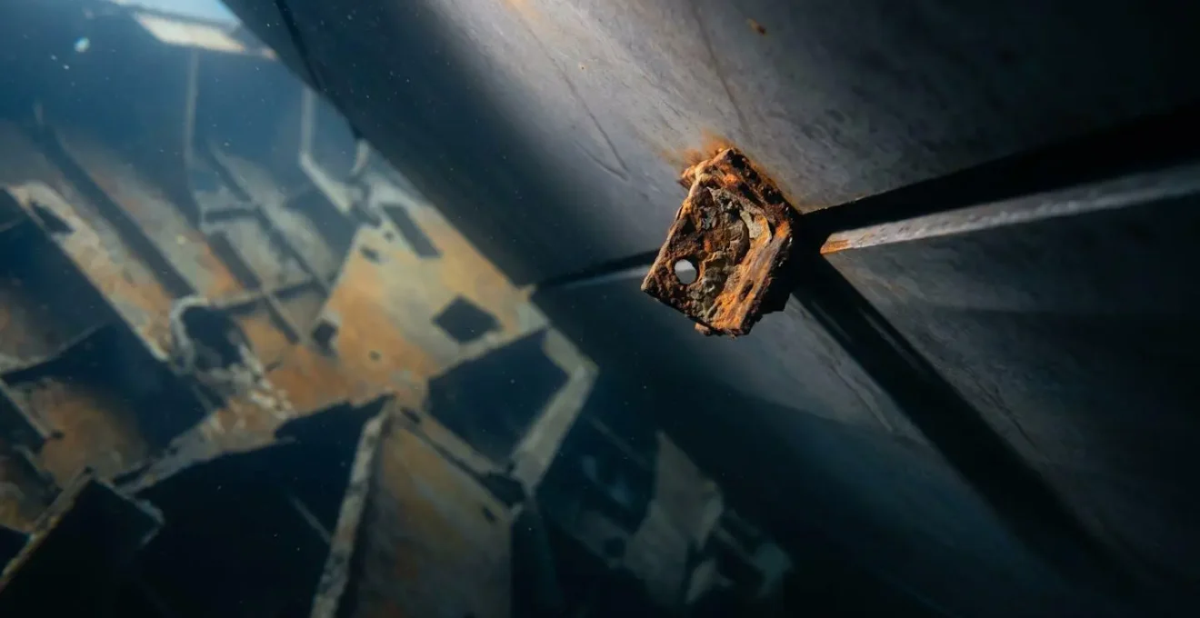 Objet métallique rouillé soutenant une structure d'épave corrodée en équilibre instable