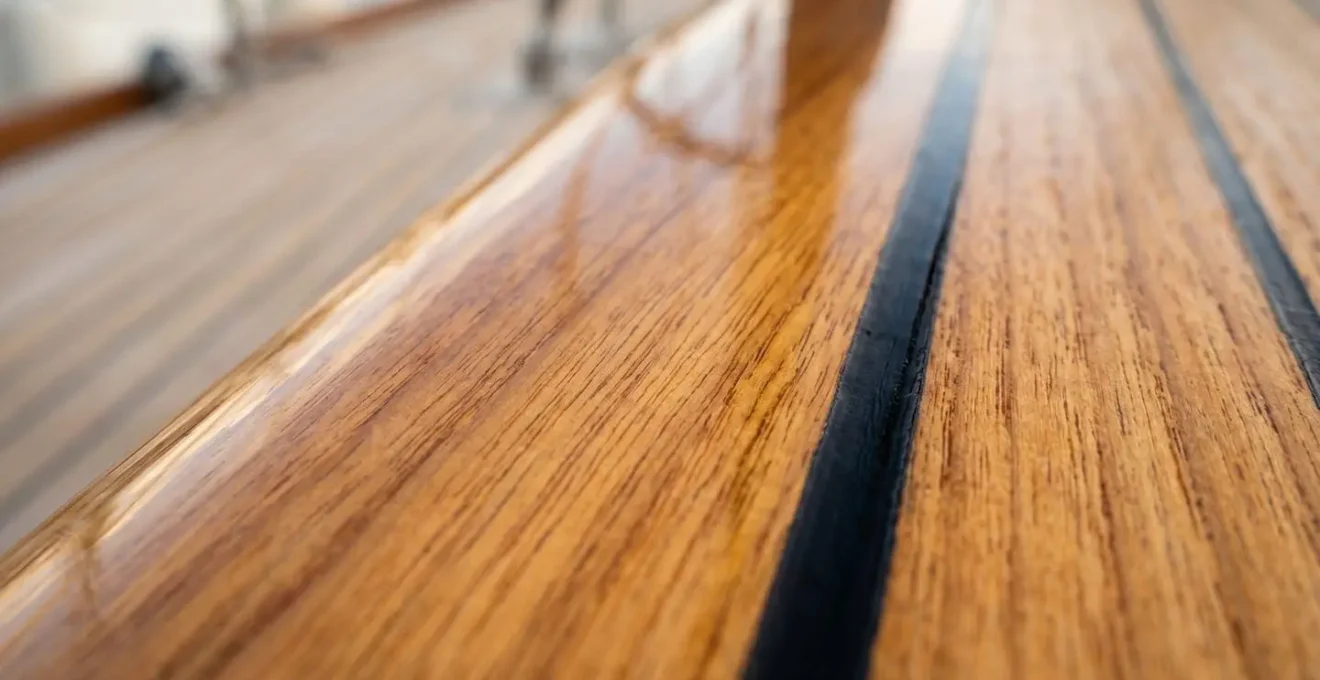 Gros plan sur le grain du bois de teck verni d'un pont de bateau classique