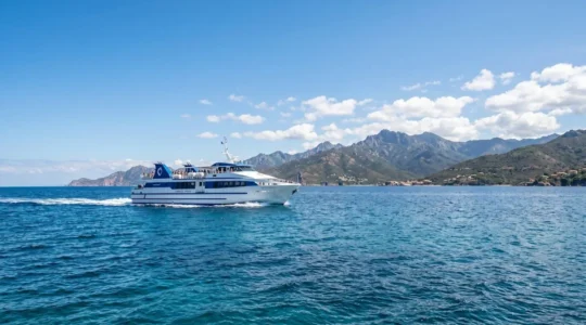 Un ferry moderne naviguant sur les eaux bleues de la Méditerranée en direction de la Corse sous un ciel ensoleillé