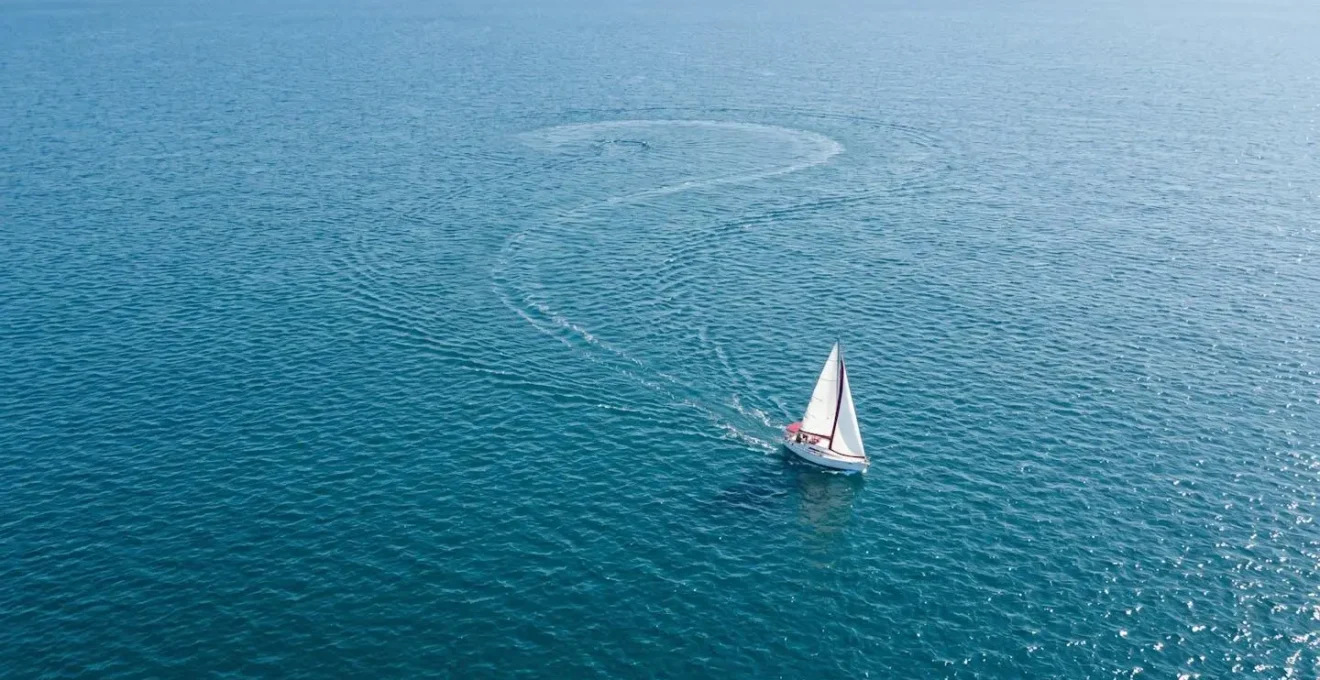 Vue aérienne illustrant la trajectoire d'un voilier exécutant la manœuvre Quick Stop pour récupérer un homme à la mer
