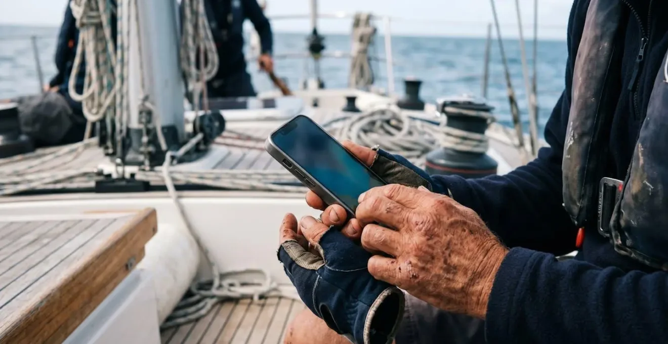 Mains de navigateur utilisant une application mobile de navigation en mer avec carte marine